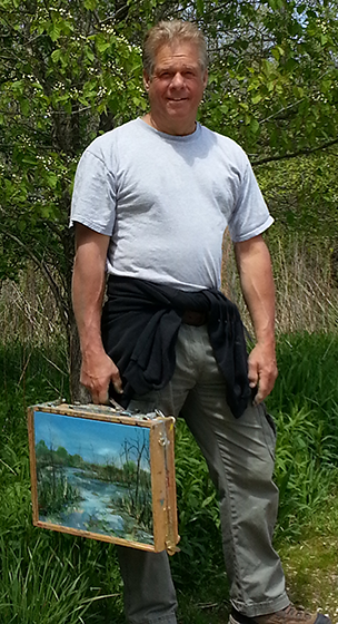 Person holding a painting outdoors in a natural setting.