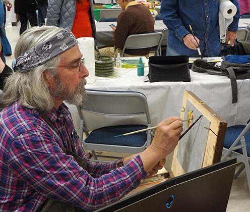 An artist painting a portrait at an event.