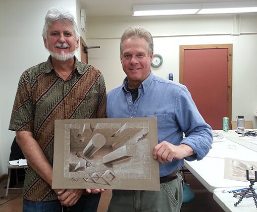 Two men holding carved relief artwork
