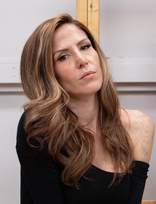 Woman with long wavy hair, neutral expression