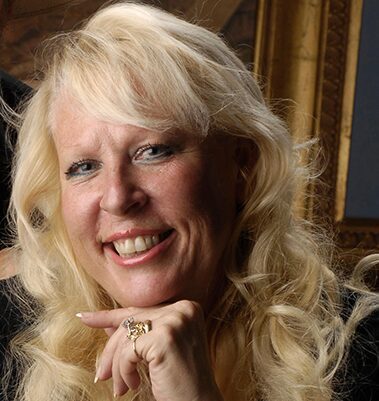Smiling blonde woman resting chin on hand