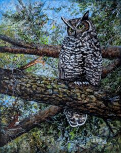 A great horned owl perched on a tree branch in a forest.