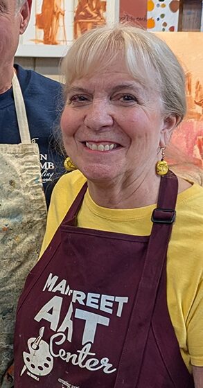 Smiling woman wearing art center apron
